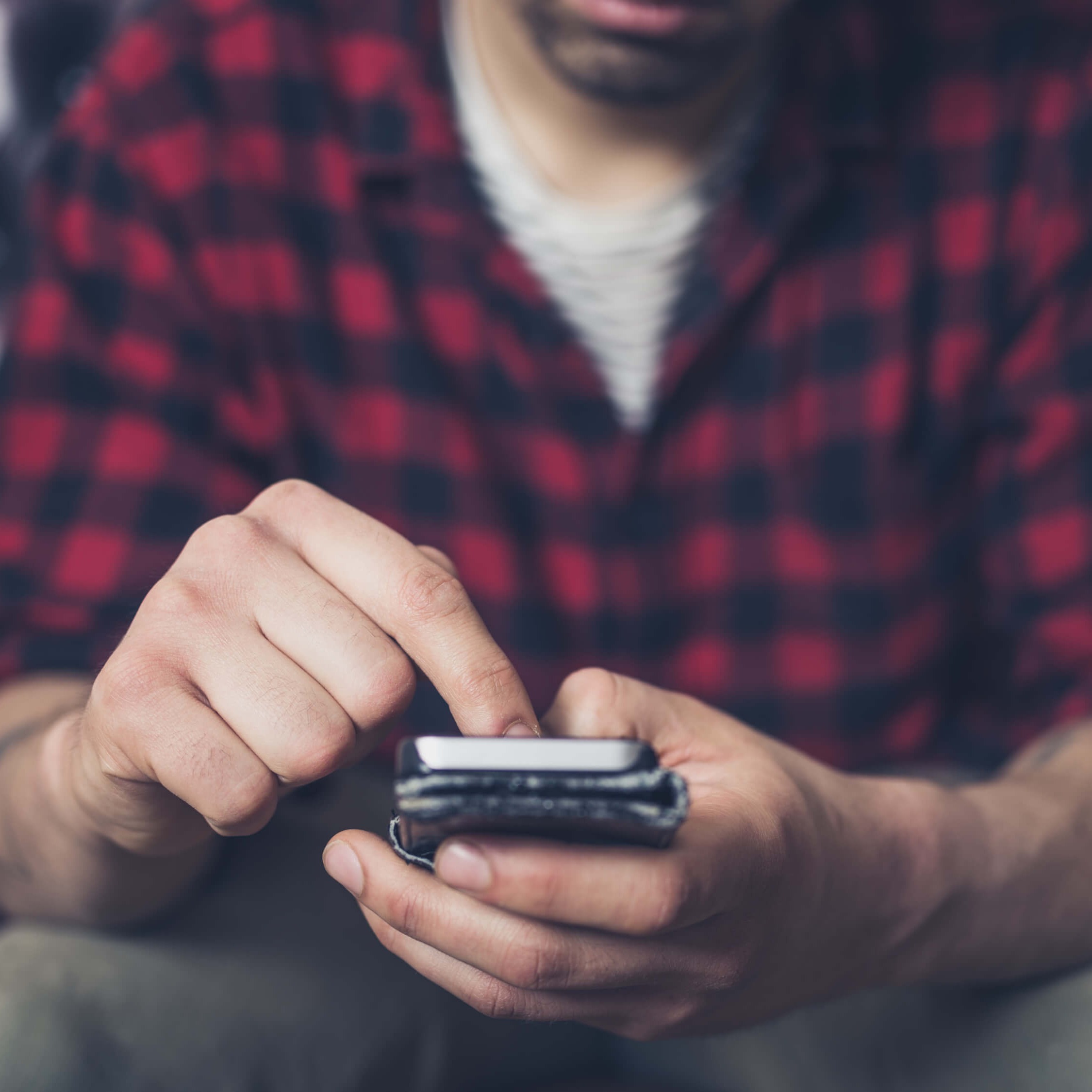 Man scrolling on smart phone - IQ Credit Union